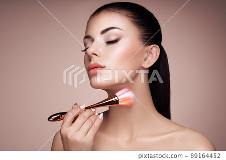 Beautiful Woman applies Skin Tone with Brush 89164452