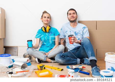 Happy boy and girl drinking coffee on floor. 89164521