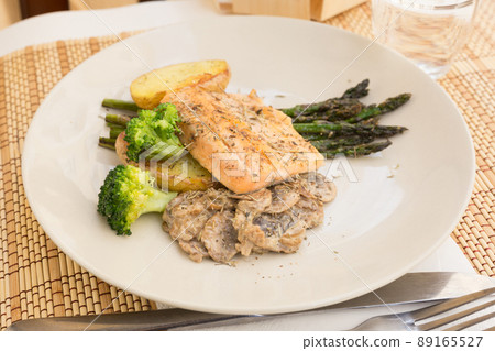dish of fried river trout fillet with garnish of broccoli, asparagus sprouts and mushroom sauce 89165527