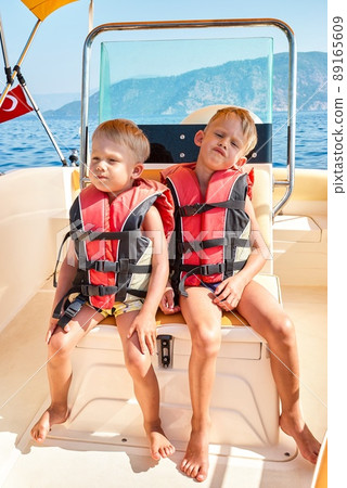 Brothers in life jackets feel bored at boat trip in Marmaris 89165609