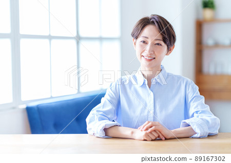 一個在客廳裡放鬆的中間女人。 一個在客廳裡放鬆的中間女人。 89167302