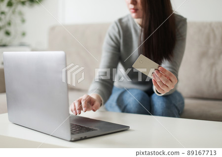 Young woman holding credit card and using laptop at home. Paying online, home shopping, internet banking, electronic store concept Young woman holding credit card and using laptop at home. Paying online, home shopping, internet banking, electronic store concept 89167713