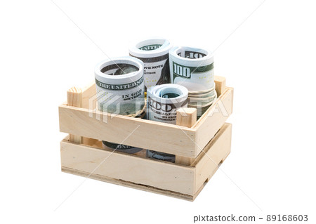 Dollars rolled into a roll and tied with a colored elastic band in a wooden box 89168603