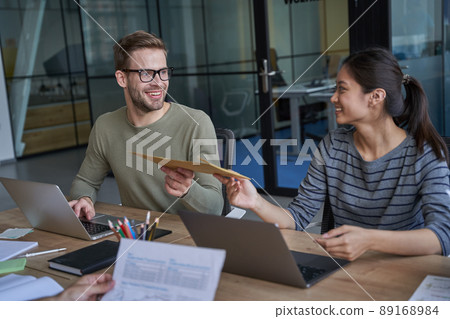Happy man and woman looking and holding envelope Happy man and woman looking and holding envelope 89168984