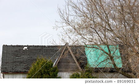 Residential Roof in Desperate Need of Repair or Replacement with peeling shingles and Tarp 89169031