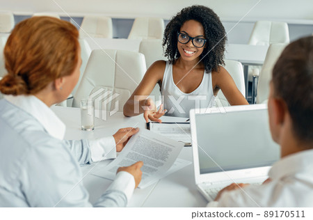 Young African business lady talking to her coworkers during meeting 89170511