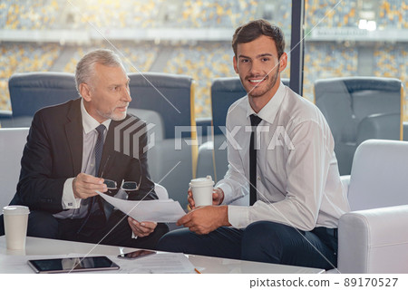 Two businessmen reviewing work documents in office 89170527