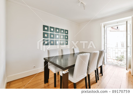 Luxurious design of the dining room with a black wooden table and light chairs 89170759