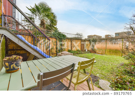 The backyard of a modern house with a seating area and a green lawn The backyard of a modern house with a seating area and a green lawn 89170765