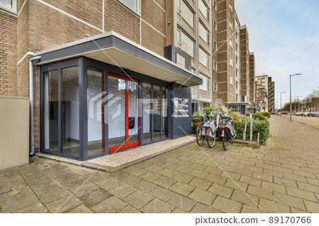 Entrance to a multi-storey residential building with parking for bicycles and a glass door Entrance to a multi-storey residential building with parking for bicycles and a glass door 89170766