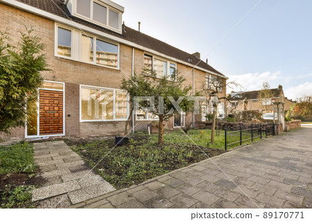 Entrance to a two-storey private brick house with a tiled walkway Entrance to a two-storey private brick house with a tiled walkway 89170771