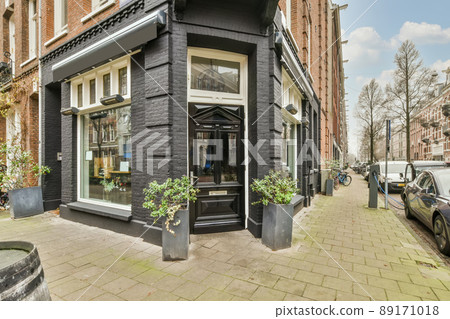 Entrance to a residential brick house with parking for cars under the house and tiled floor Entrance to a residential brick house with parking for cars under the house and tiled floor 89171018