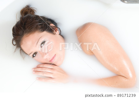 beautiful woman relaxing in milk bath beautiful woman relaxing in milk bath 89171239