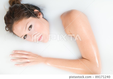 beautiful woman relaxing in milk bath beautiful woman relaxing in milk bath 89171240