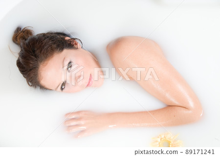 beautiful woman relaxing in milk bath beautiful woman relaxing in milk bath 89171241