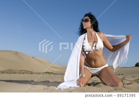 woman on the sand with bikini under blue sky woman on the sand with bikini under blue sky 89171395