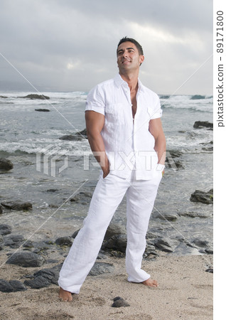 Beautiful man near the sea wearing white clothes 89171800
