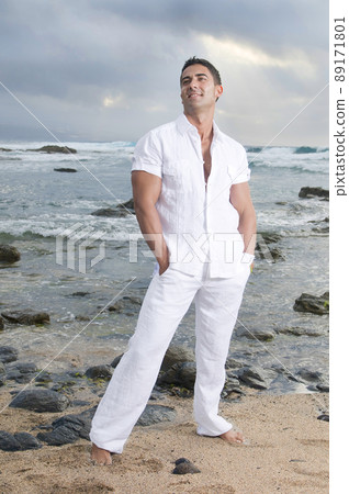 Beautiful man near the sea wearing white clothes 89171801