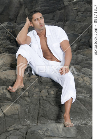 Beautiful man near the sea wearing white clothes Beautiful man near the sea wearing white clothes 89171817