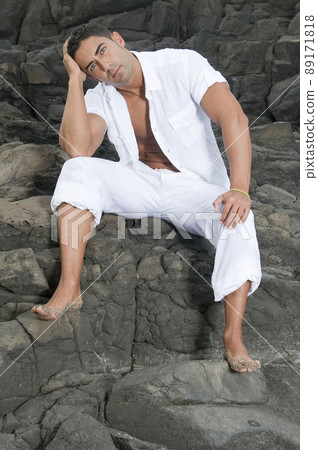 Beautiful man near the sea wearing white clothes 89171818