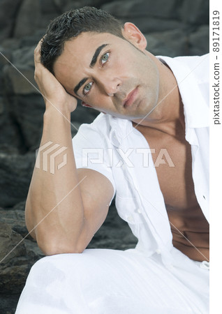 Beautiful man near the sea wearing white clothes Beautiful man near the sea wearing white clothes 89171819