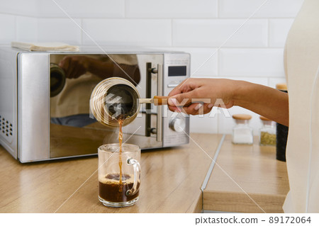 Closeup view of pouring hot coffe in the cup 89172064
