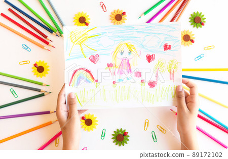 A child draws a postcard for mother's day. Beautiful landscape with mom drawn with pencils. 89172102