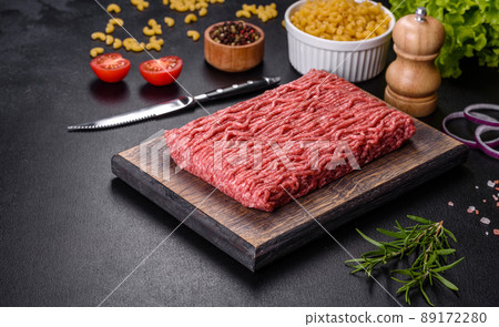 Fresh raw mince with spices and herbs on a dark concrete background Fresh raw mince with spices and herbs on a dark concrete background 89172280