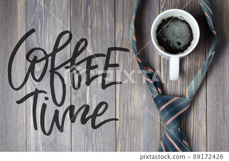 Men's tie and coffee in a white Cup on wooden background. Handwr Men's tie and coffee in a white Cup on wooden background. Handwr 89172426