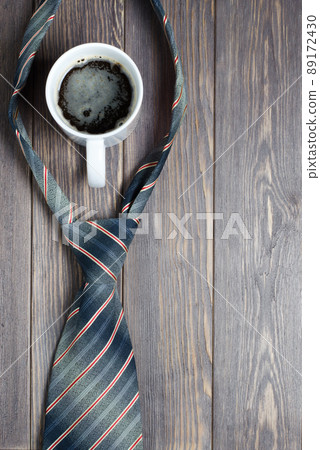 Men's tie and coffee in a white Cup on wooden background. Flat t Men's tie and coffee in a white Cup on wooden background. Flat t 89172430