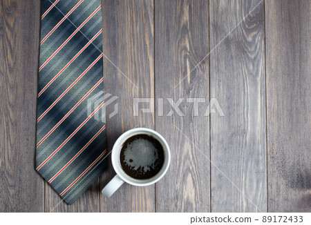 Men's tie and coffee in a white Cup on wooden background Men's tie and coffee in a white Cup on wooden background 89172433