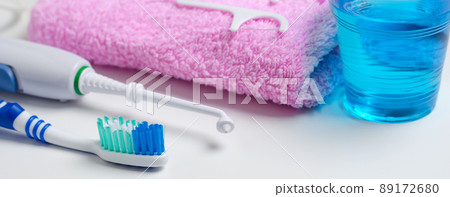Dental hygiene. Toothbrush, mouthwash, pink towel, dental floss, oral irrigator. Horizontal photo. Dental hygiene. Toothbrush, mouthwash, pink towel, dental floss, oral irrigator. Horizontal photo. 89172680