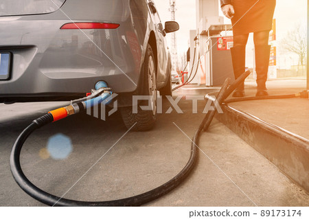 Refueling car. Pump gas at petrol fuel station. Gasoline oil nozzle tank from hand person. Automotive industry or transportation concept. Refueling car. Pump gas at petrol fuel station. Gasoline oil nozzle tank from hand person. Automotive industry or transportation concept. 89173174