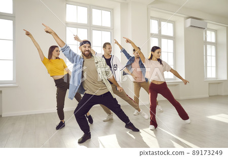 Group of energetic hip hop dancers have fun rehearsing dance moves while learning new dance. Group of energetic hip hop dancers have fun rehearsing dance moves while learning new dance. 89173249
