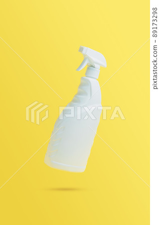 Levitation, flying blank toilet or window cleaner bottle with sprayer. Isolated on yellow background. White plastic packaging. Household chemistry. Falling in air single object. Detergent with trigger 89173298