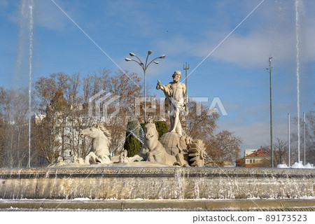 Fountain of Neptune (Fuente de Neptuno). Winter photo of the neoclassical style statue of Neptune and horses at the center of the Canovas del Castillo square in Madrid, Spain. 89173523