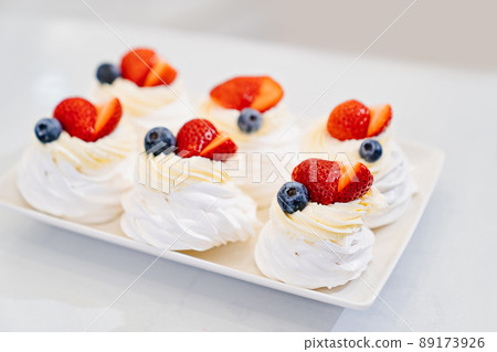 strawberries, blueberries and cream decorates to Anna Pavlova cakes. 89173926