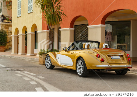 Exclusive vintage car is standing on narrow small streets, replica on the famous convertible car in French Riviera, Cap Ferrat, retro type, gold color, roadster, cote dazur 89174216