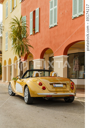 Exclusive vintage car is standing on narrow small streets, replica on the famous convertible car in French Riviera, Cap Ferrat, retro type, gold color, roadster, cote dazur 89174217