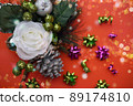 Orange background with christmas decoration: white rose and pine cone 89174810