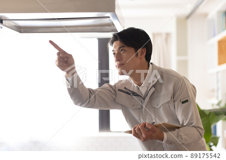 A man wearing work clothes checking gas A man wearing work clothes checking gas 89175542