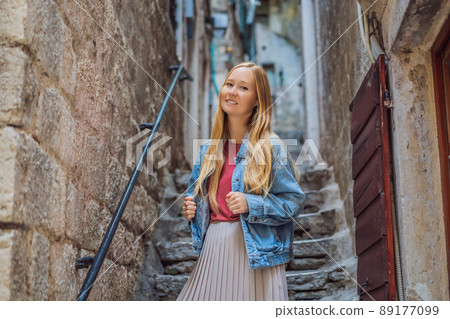Woman tourist enjoying Colorful street in Old town of Kotor on a sunny day, Montenegro. Travel to Montenegro concept 89177099