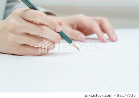 Woman's hand holding a pencil 89177536
