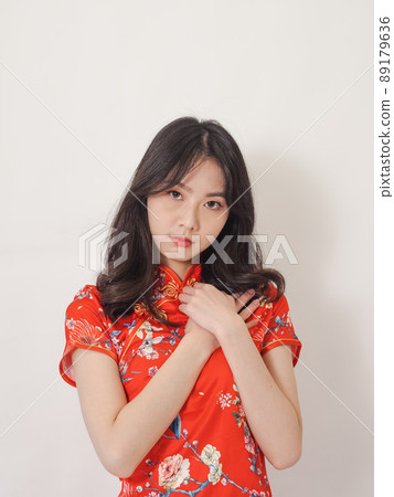 Young asian woman wearing traditional cheongsam qipao dress with hands on chest over isolated white background. 89179636
