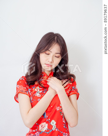 Young asian woman wearing traditional cheongsam qipao dress with hands on chest over isolated white background. 89179637