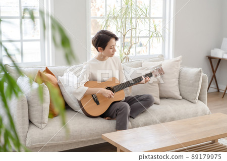 Woman playing the guitar Middle Woman playing the guitar Middle 89179975