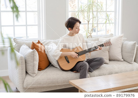 Woman playing the guitar Middle Woman playing the guitar Middle 89179976