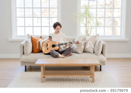 Female middle delivery playing the guitar Female middle delivery playing the guitar 89179979