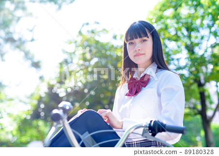 High school girls who go to school by bicycle, beautiful fresh green background, going to and from school 89180328