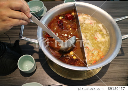 Someone scooped up the spicy hot pot soup base with a spoon Yuanyang Hotpot 89180457